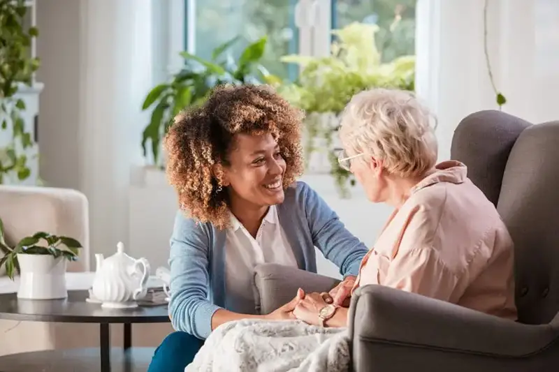 Senior woman sitting with her caregiver