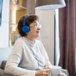 Senior woman listening to podcast on her headphones