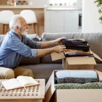 Senior man packing up clothes