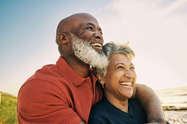 senior couple watching the sun set on the beach